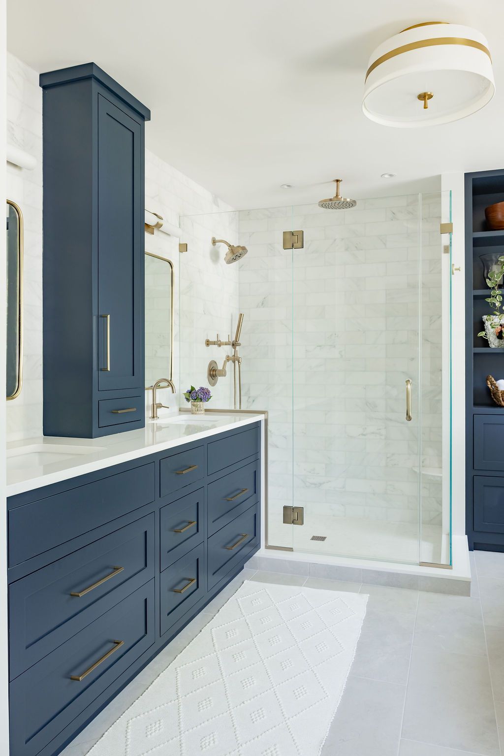 Blue and white bathroom with a shower, sink, and storage cabinets.