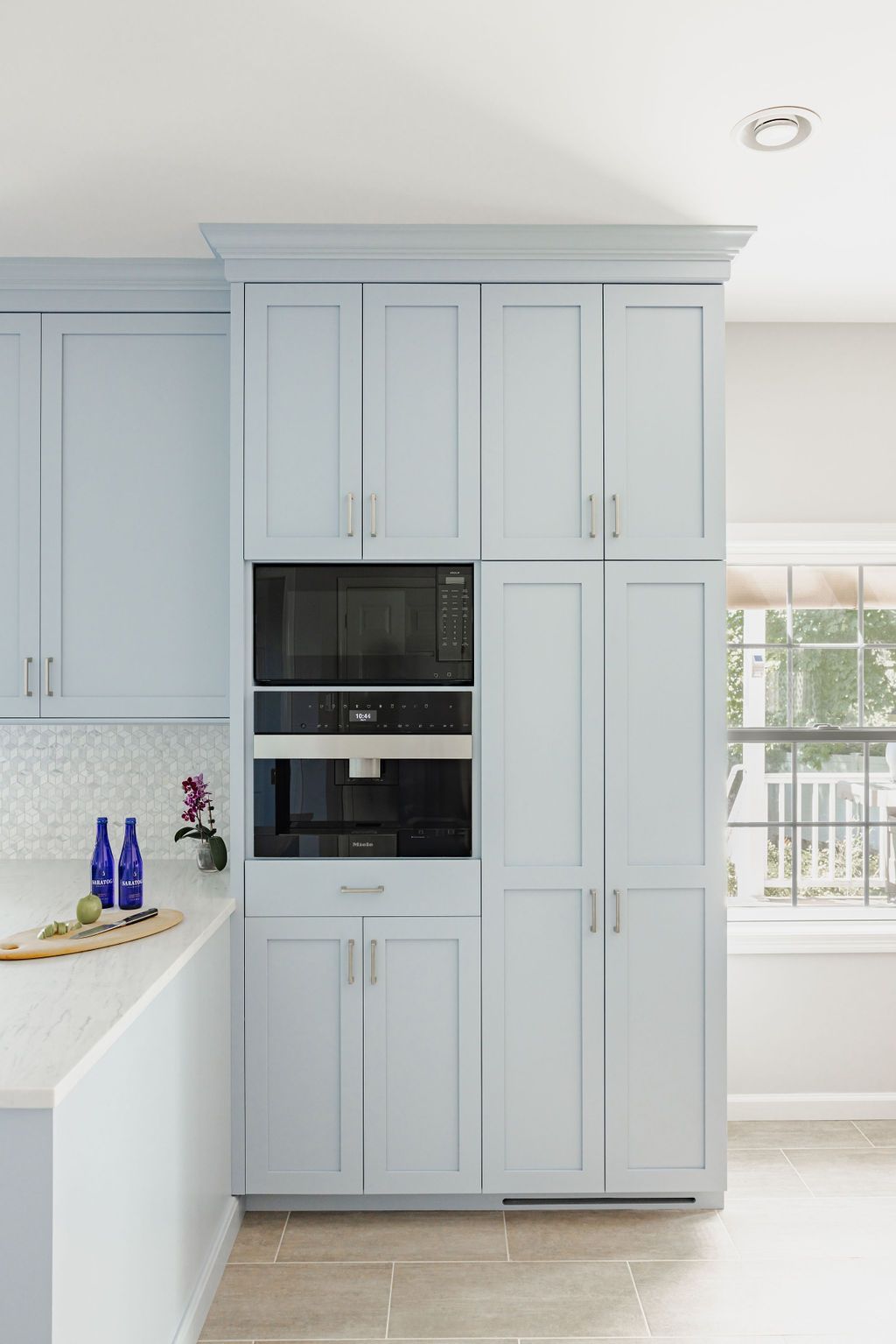 Light blue kitchen cabinets with built-in microwave and coffee maker.