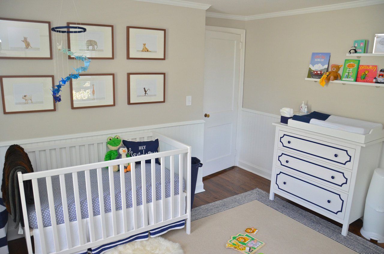 Baby nursery with a crib, changing table, wall art, and books.