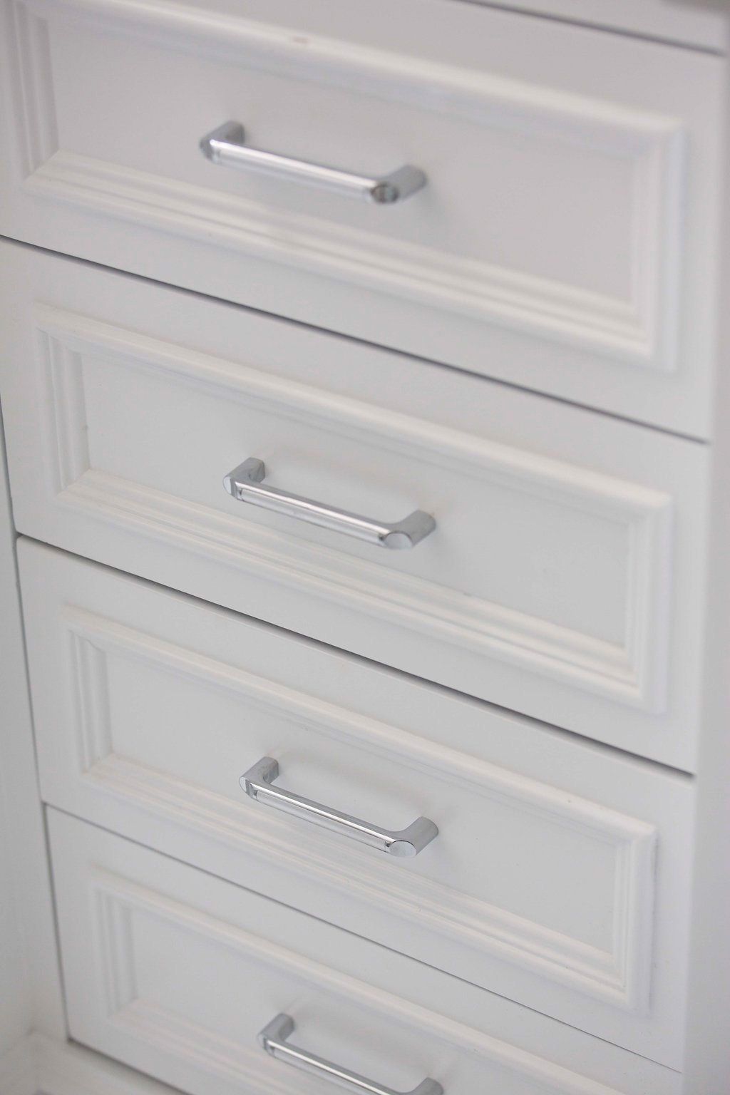White cabinet drawers with silver handles.