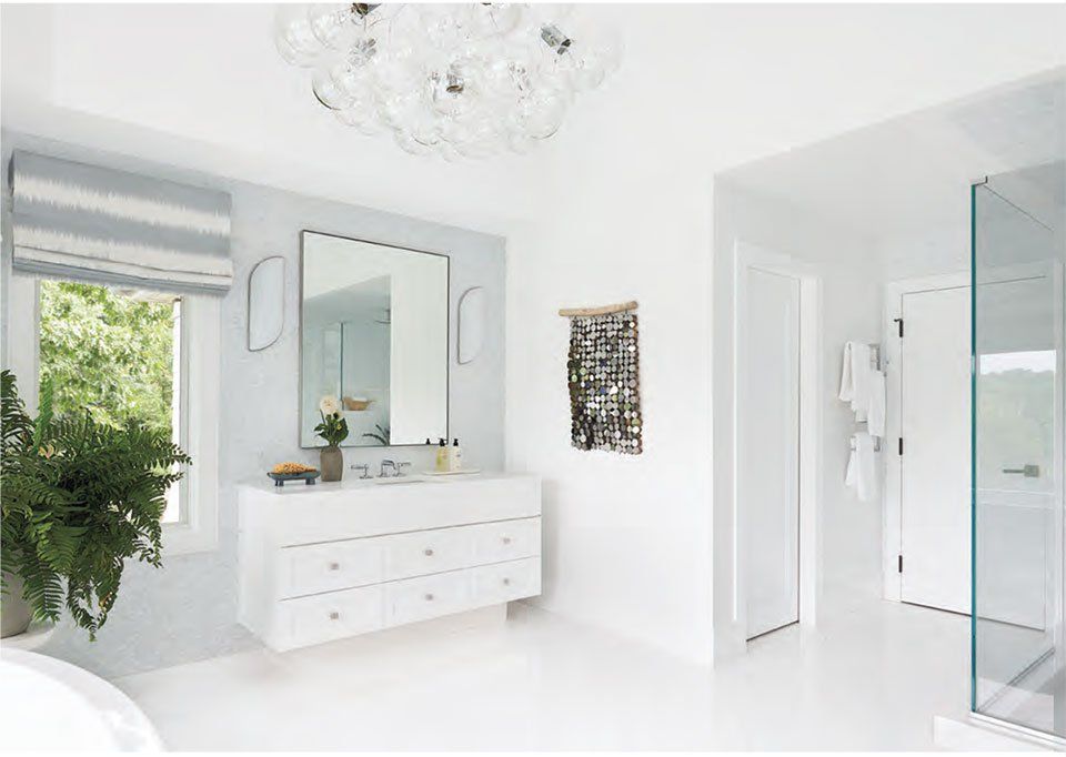 White modern bathroom with floating vanity, large mirror, and glass shower.