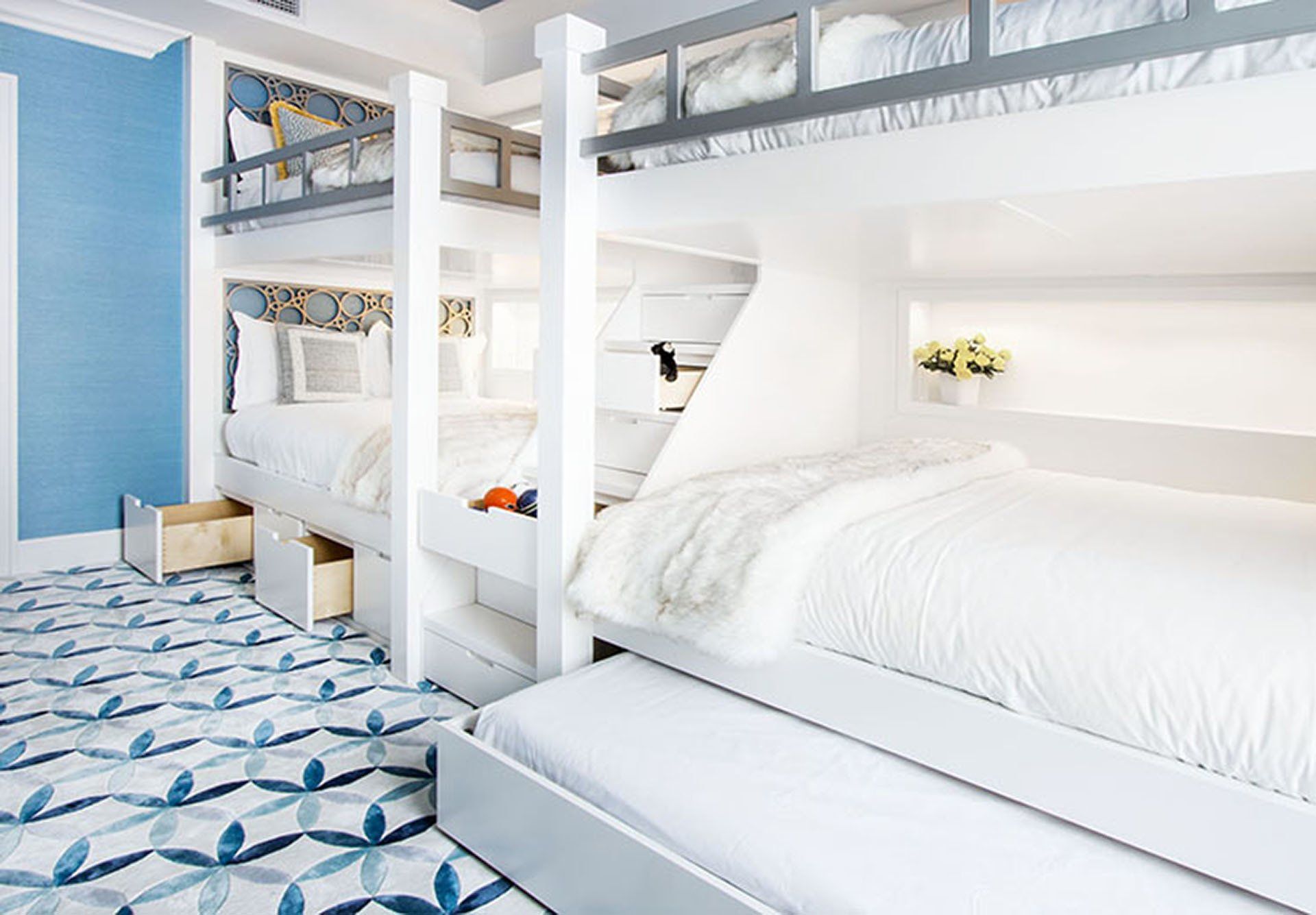 Bunk beds in a bright room with light blue walls and patterned carpet.