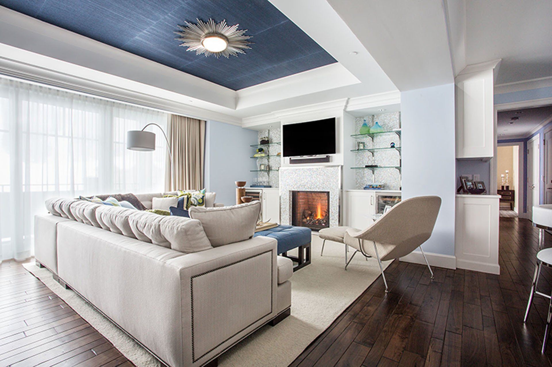 Living room with a fireplace, sofa, and blue ceiling.