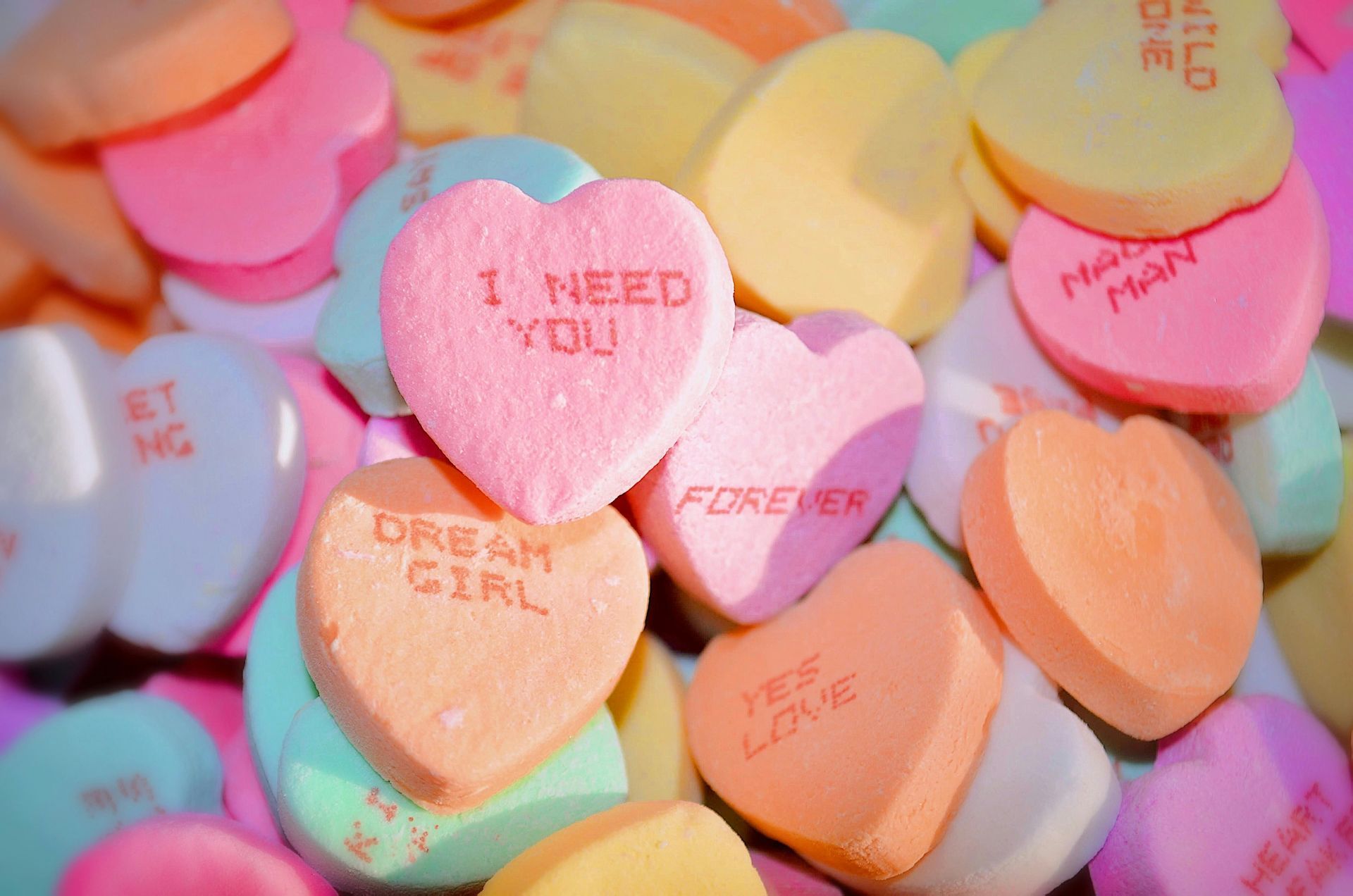 Pile of colorful heart-shaped candies with romantic phrases like 