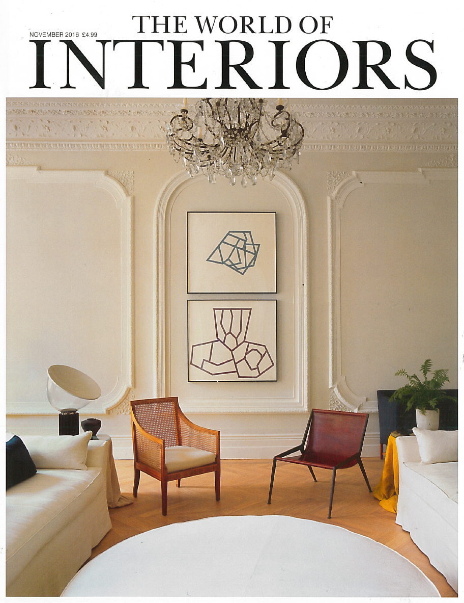 Interior magazine cover featuring a room with art, a chandelier, chairs, and a round rug.