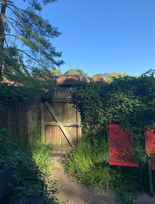 A wooden gate with a red chair in front of it.