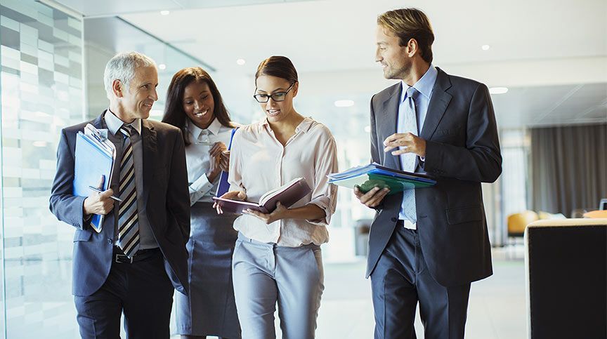 Person in a professional setting, smiling and engaging with coworkers, symbolizing bottom-up leaders