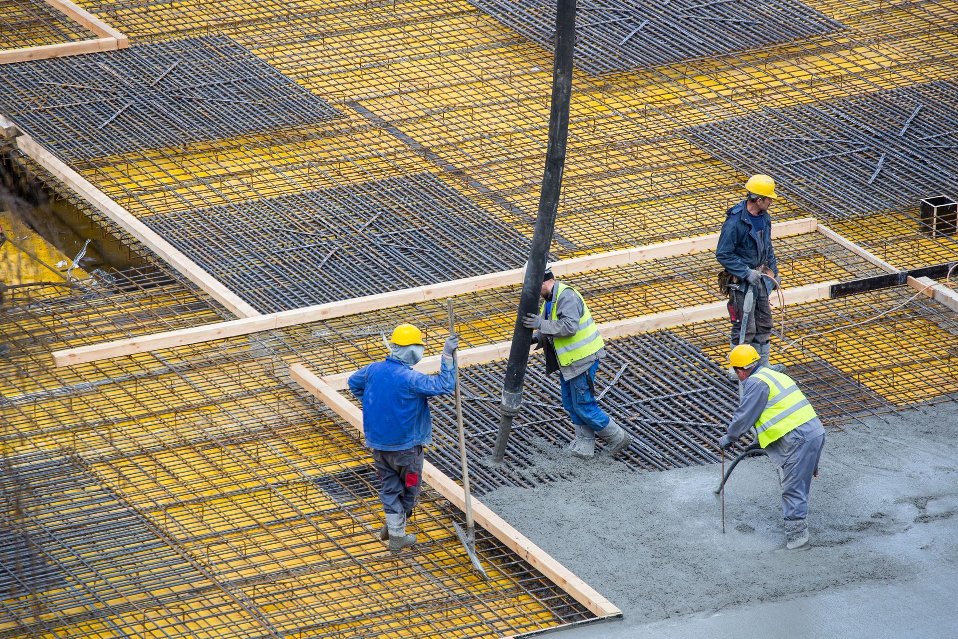 workers installing concrete floor at commercial construction site