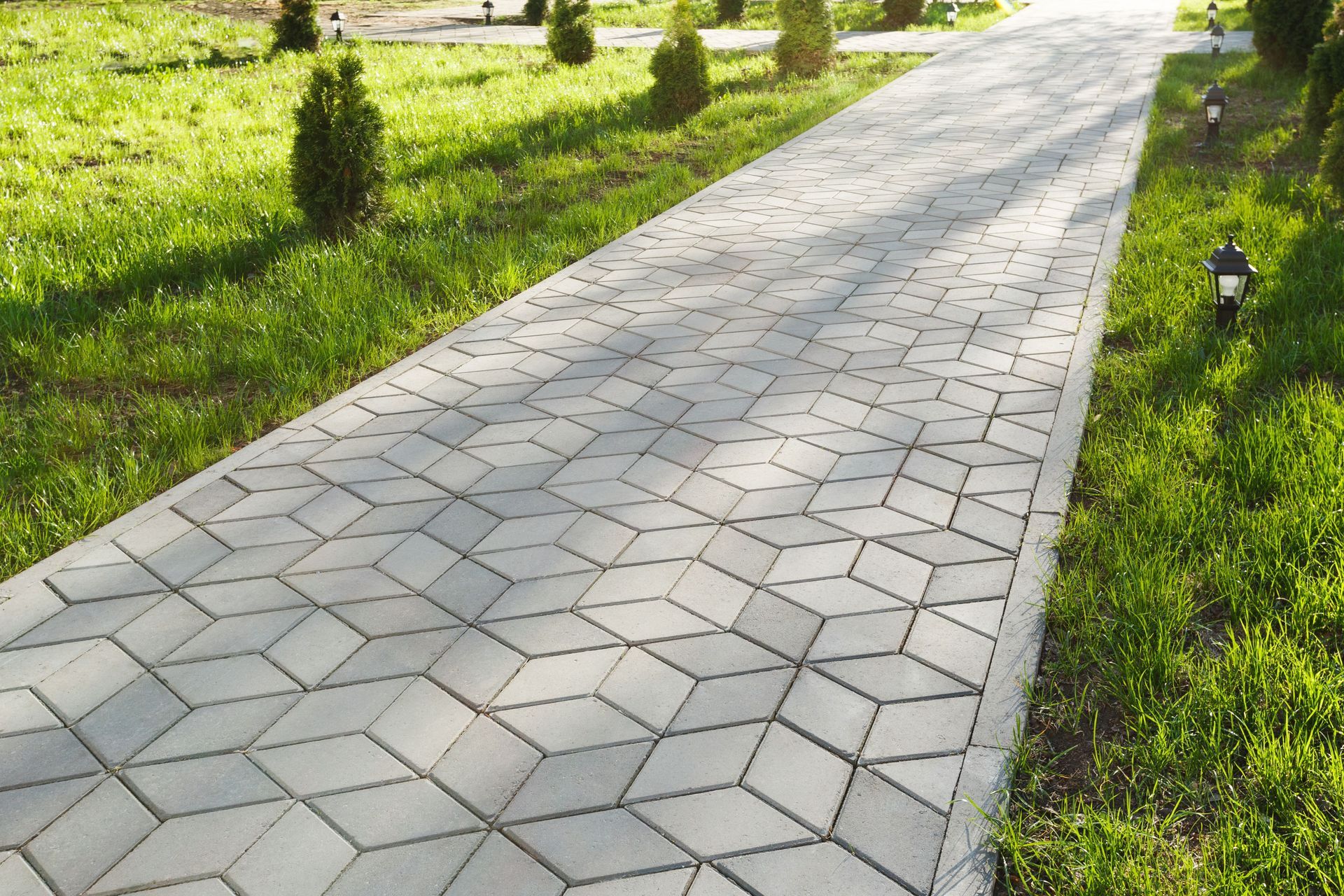 decorative concrete diamond shaped tile pathway in grass