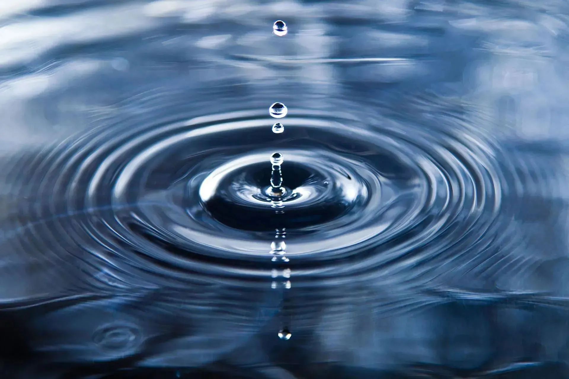 Puddle with water droplets suspended in mid-air above the surface