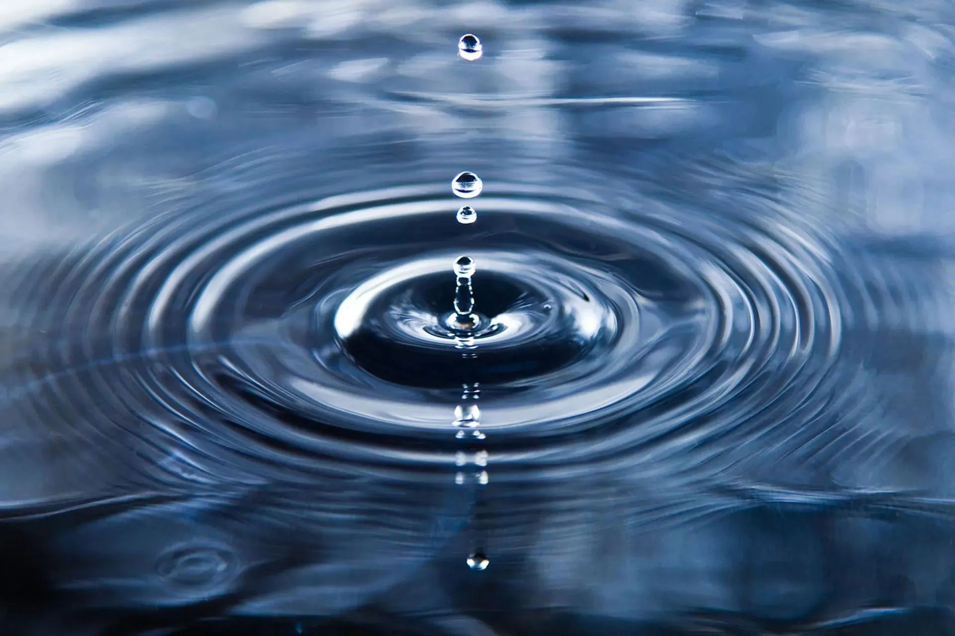 Close-up of water droplets creating ripples on a calm surface