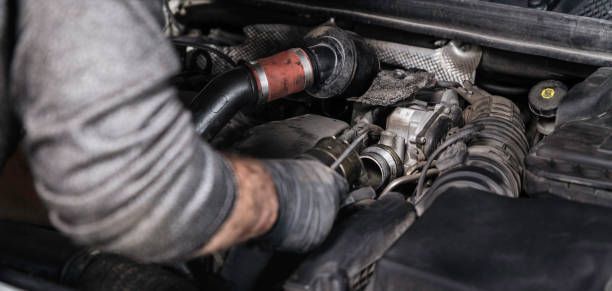 A Man Is Working On The Engine Of A Car — Transtate Trailers & 4wd In Belconnen, ACT