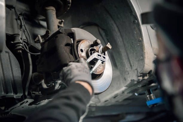 Mechanic Using a Tool to Adjust a Car's Disc Brake — Transtate Trailers & 4wd In Belconnen, ACT