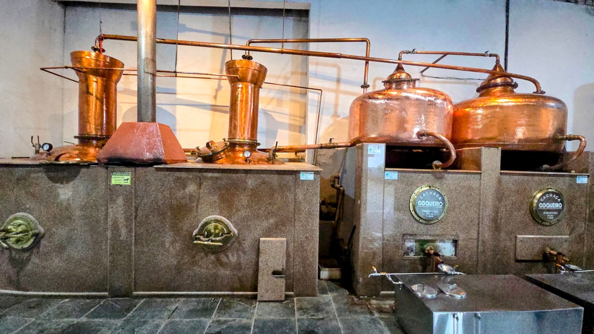 Traditional copper stills inside a cachaça distillery in Paraty, Brazil, used for producing artisanal sugarcane liquor.