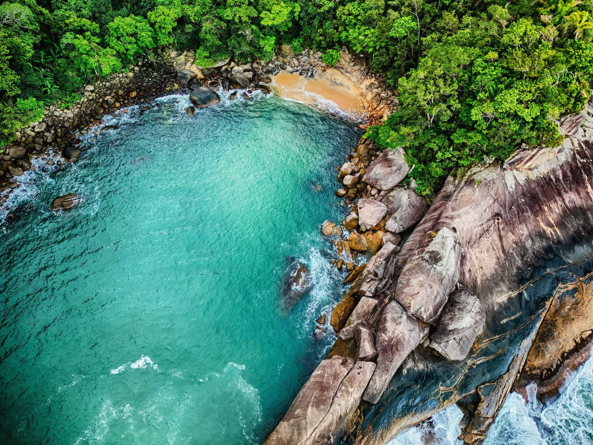 Aerial view of Praia do Caxadaço surrounded by rock formations and forest, Ilha Grande
