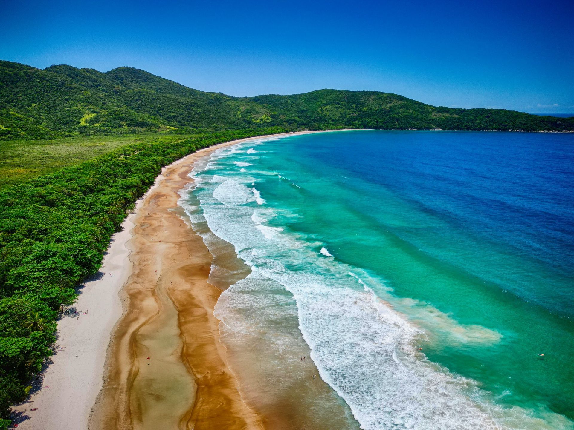 Drone view from a beach with white sands and waves