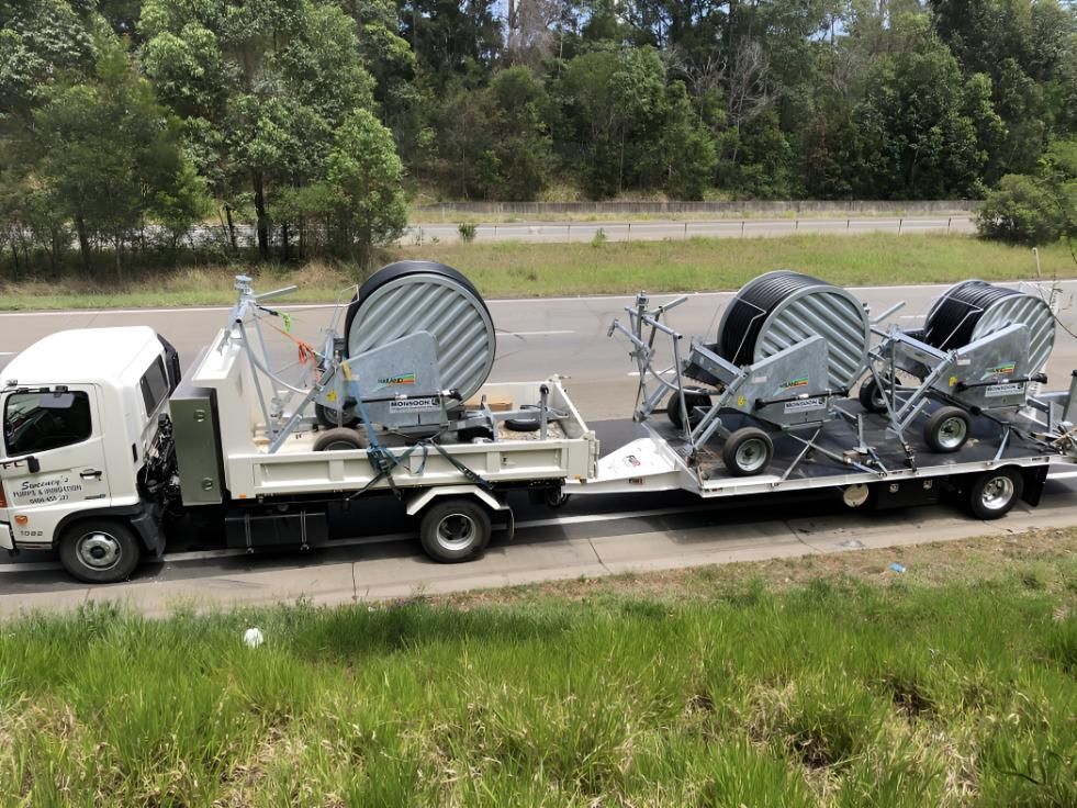 A Truck is Carrying a Trailer With a Bunch of Hose Reels on It — Sweeney's Pumps & Irrigation In Medowie, NSW
