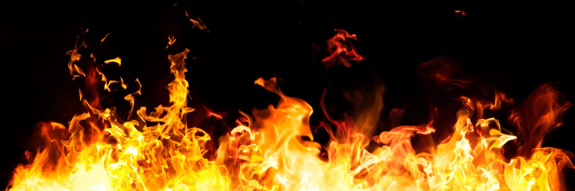 Flames erupting against a black background; yellow, orange, and red hues.
