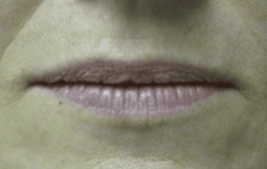 A close up of a woman 's lips with pink lipstick.