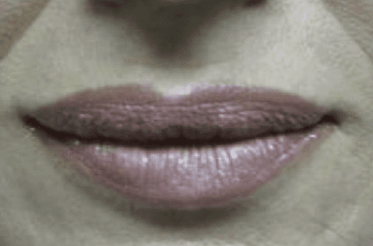 A close up of a woman 's lips with pink lipstick