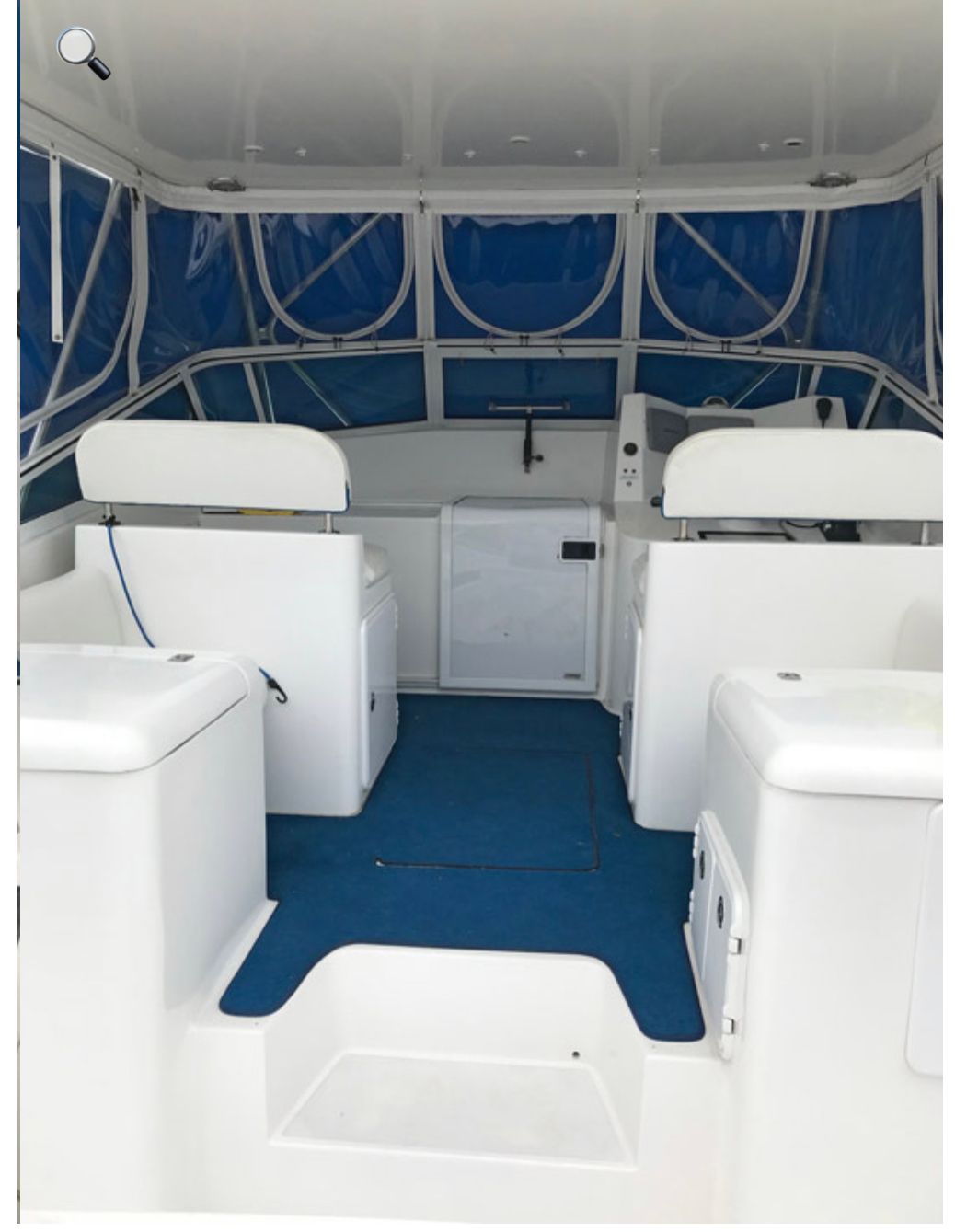 The inside of a white boat with a blue floor