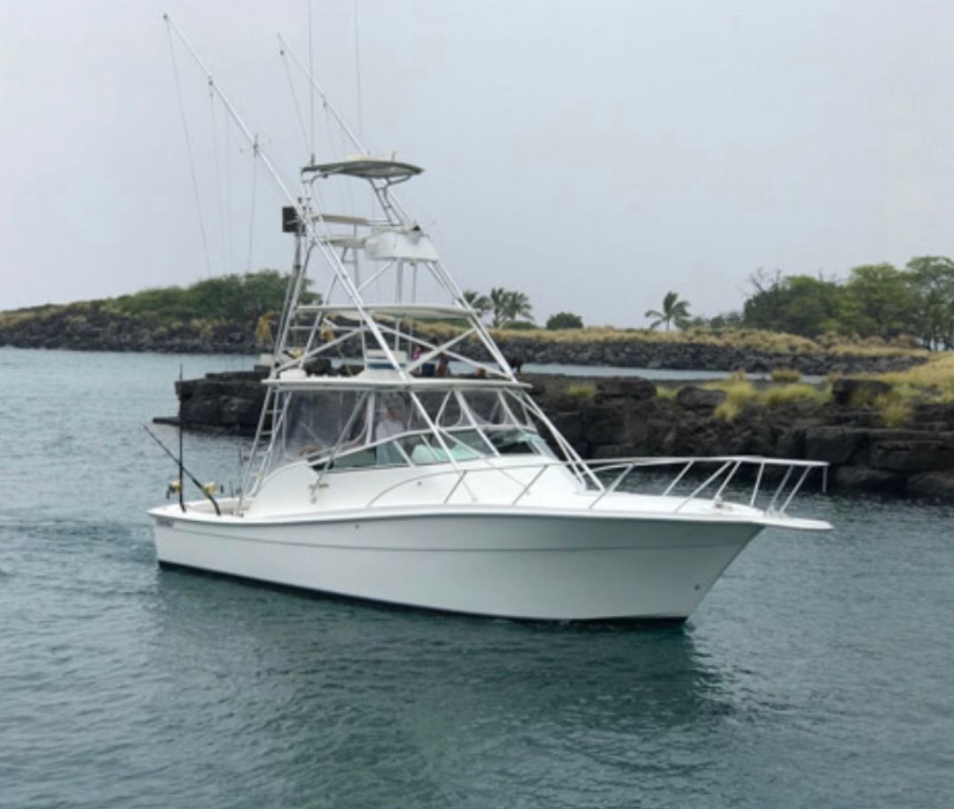 A white boat is floating on top of a body of water.