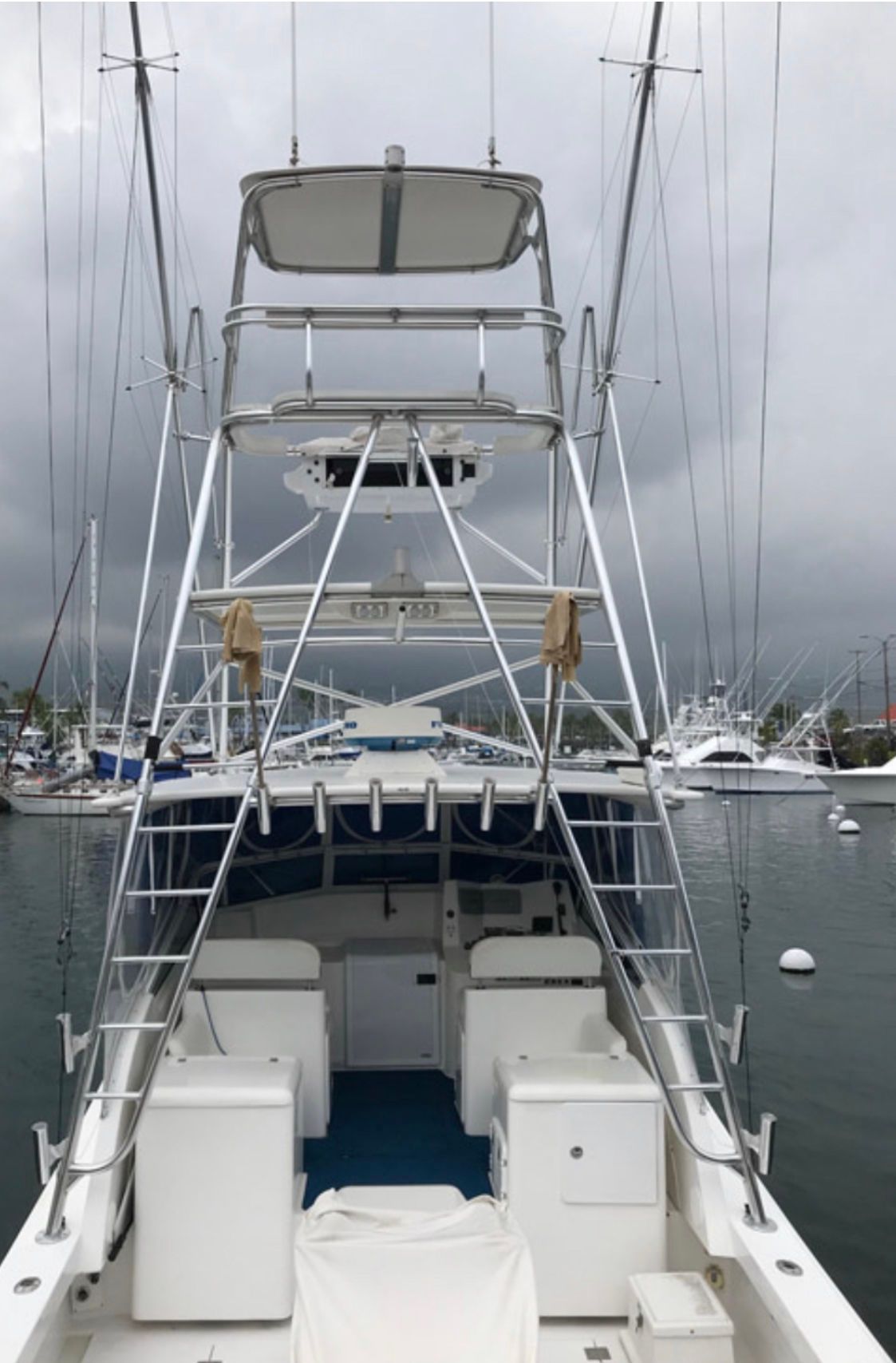 A large white boat is docked in a harbor.