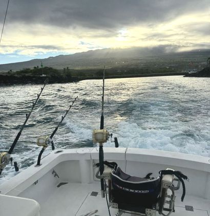 A boat with fishing rods and a chair on the deck