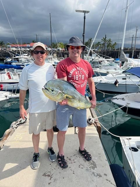 Two men standing on a dock holding a large fish