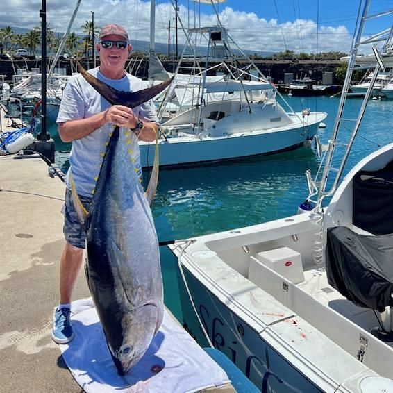 A man is standing next to a boat holding a large fish