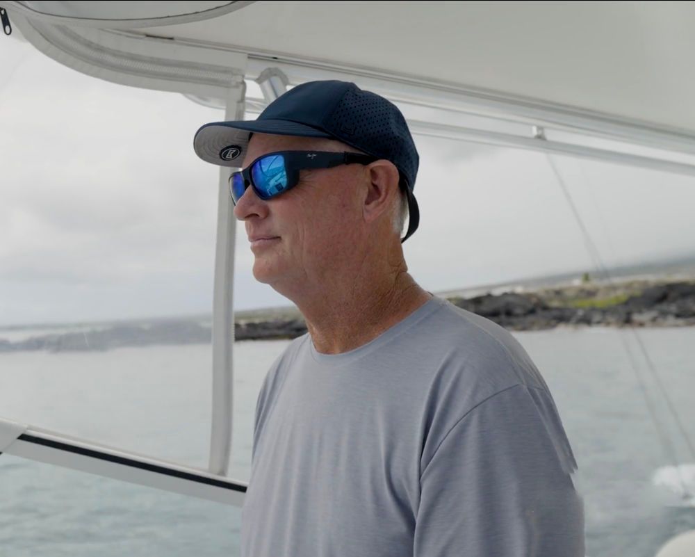 A man wearing sunglasses and a hat on a boat