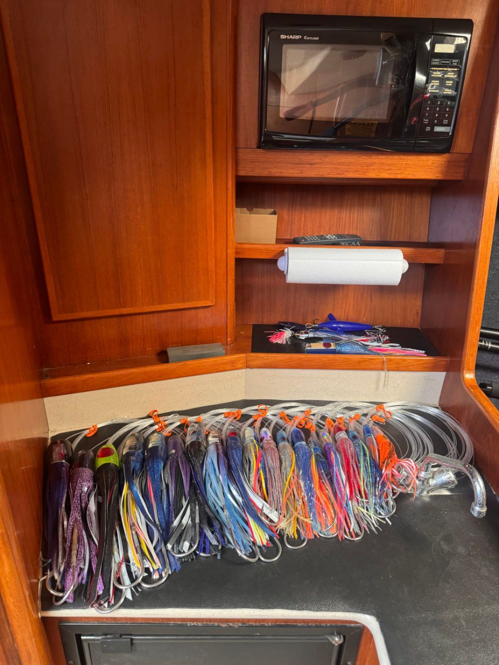 A bunch of lures are sitting on a table in a boat..