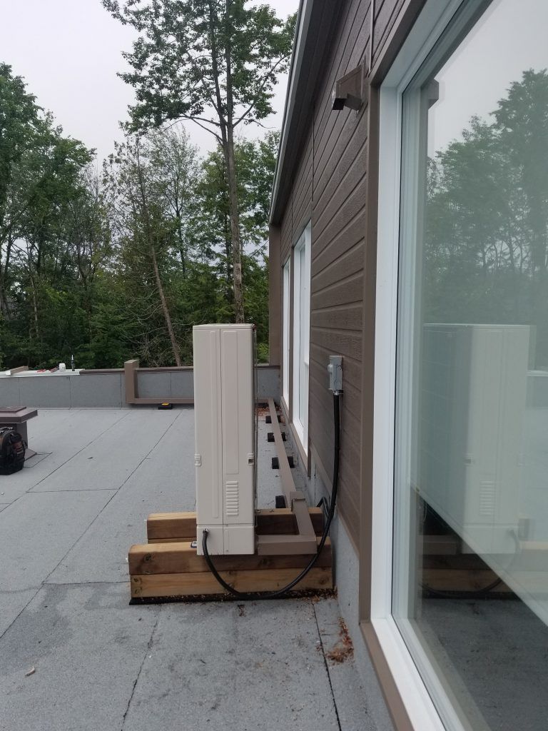 Un bâtiment avec une porte coulissante en verre et un chauffage sur le côté