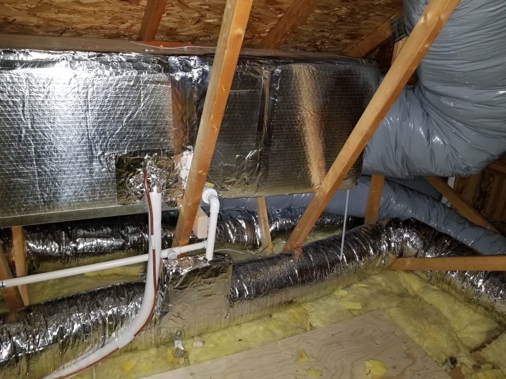 Il y a beaucoup de tuyaux et de conduits dans le grenier.