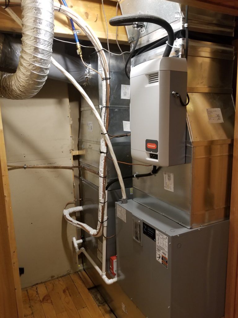 Une photo d'un système de chauffage et de climatisation dans un sous-sol.