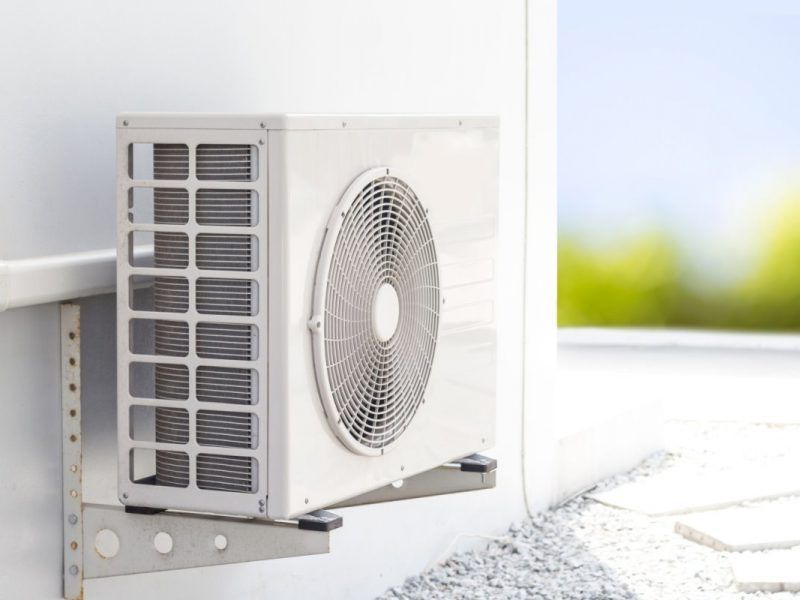 Unité de climatisation blanche fixée sur un mur extérieur.