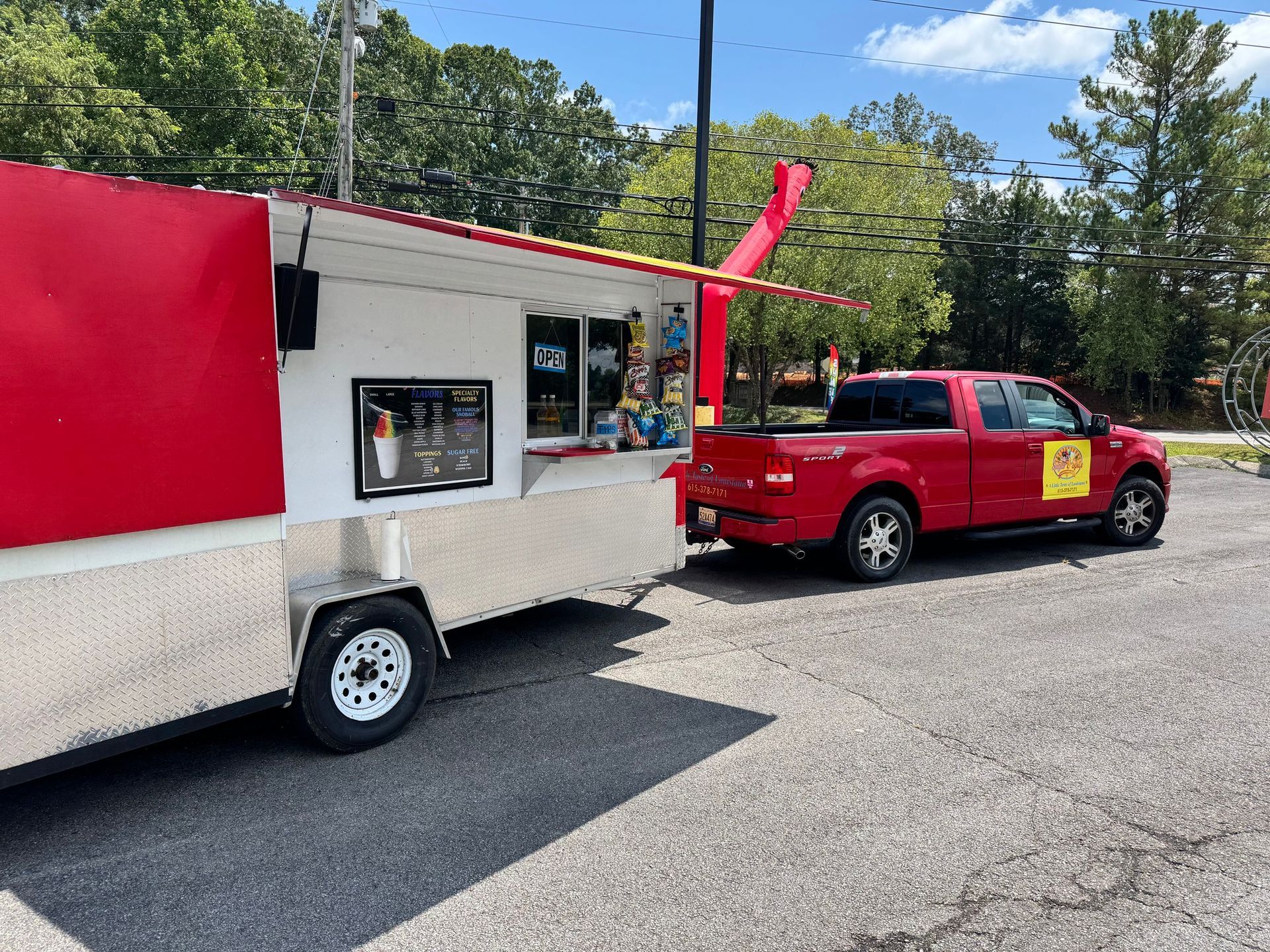 Red food truck hitched to a red pickup truck