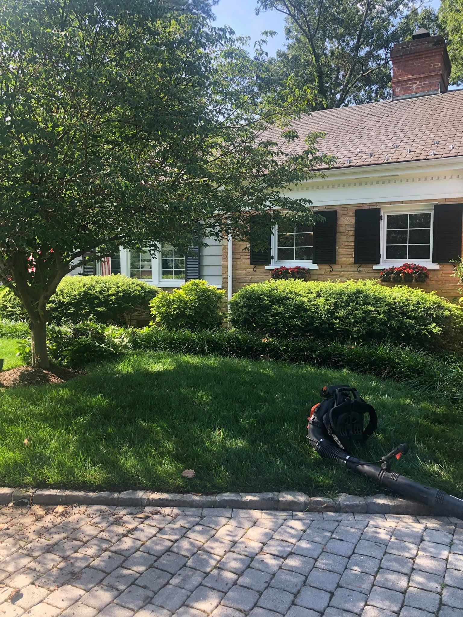 A lawn blower is sitting in front of a house.