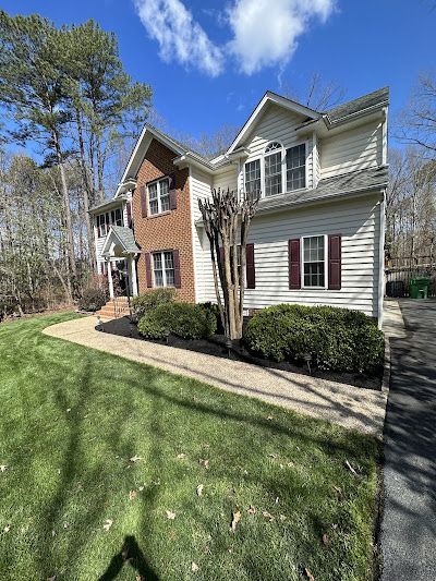 A large house with a lot of windows and a lush green lawn.