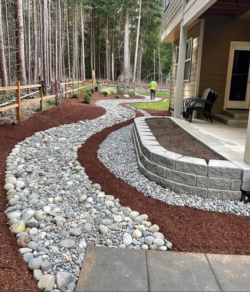 A brick walkway leading to a wooden deck in a backyard.