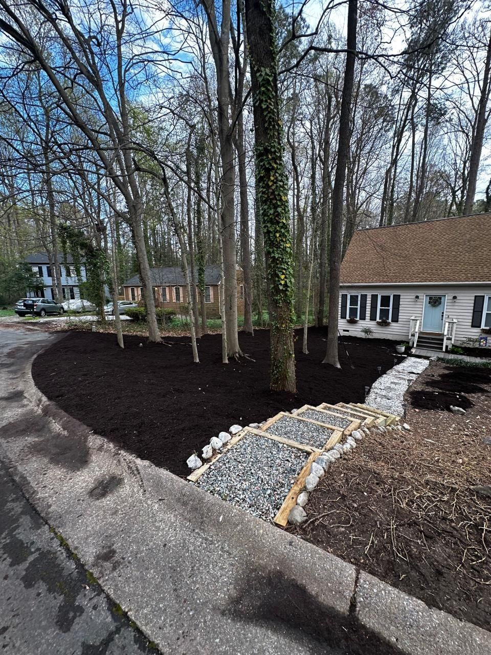 A backyard with a brick patio and trees in the background.