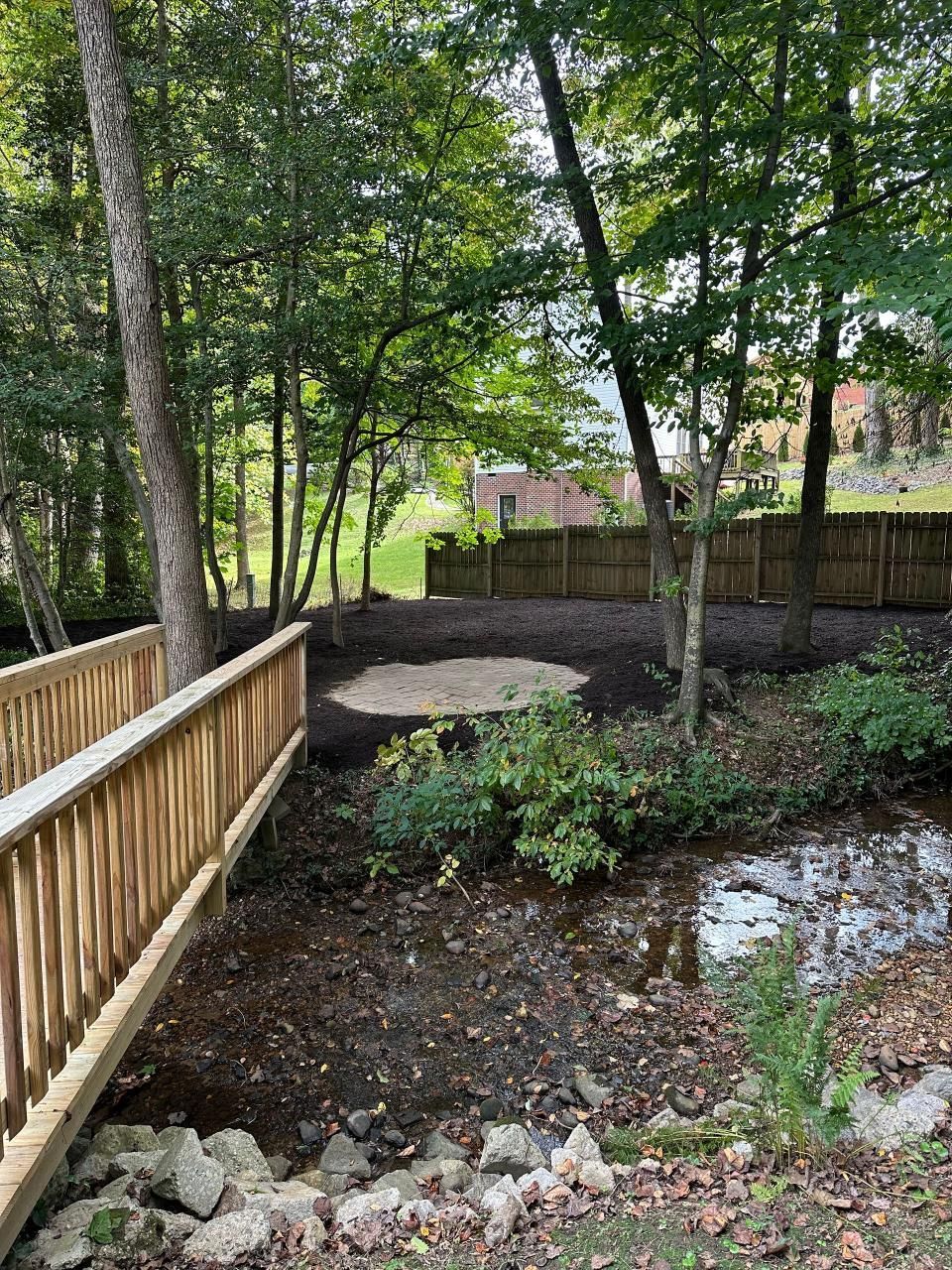 A wooden bridge over a stream in the woods.