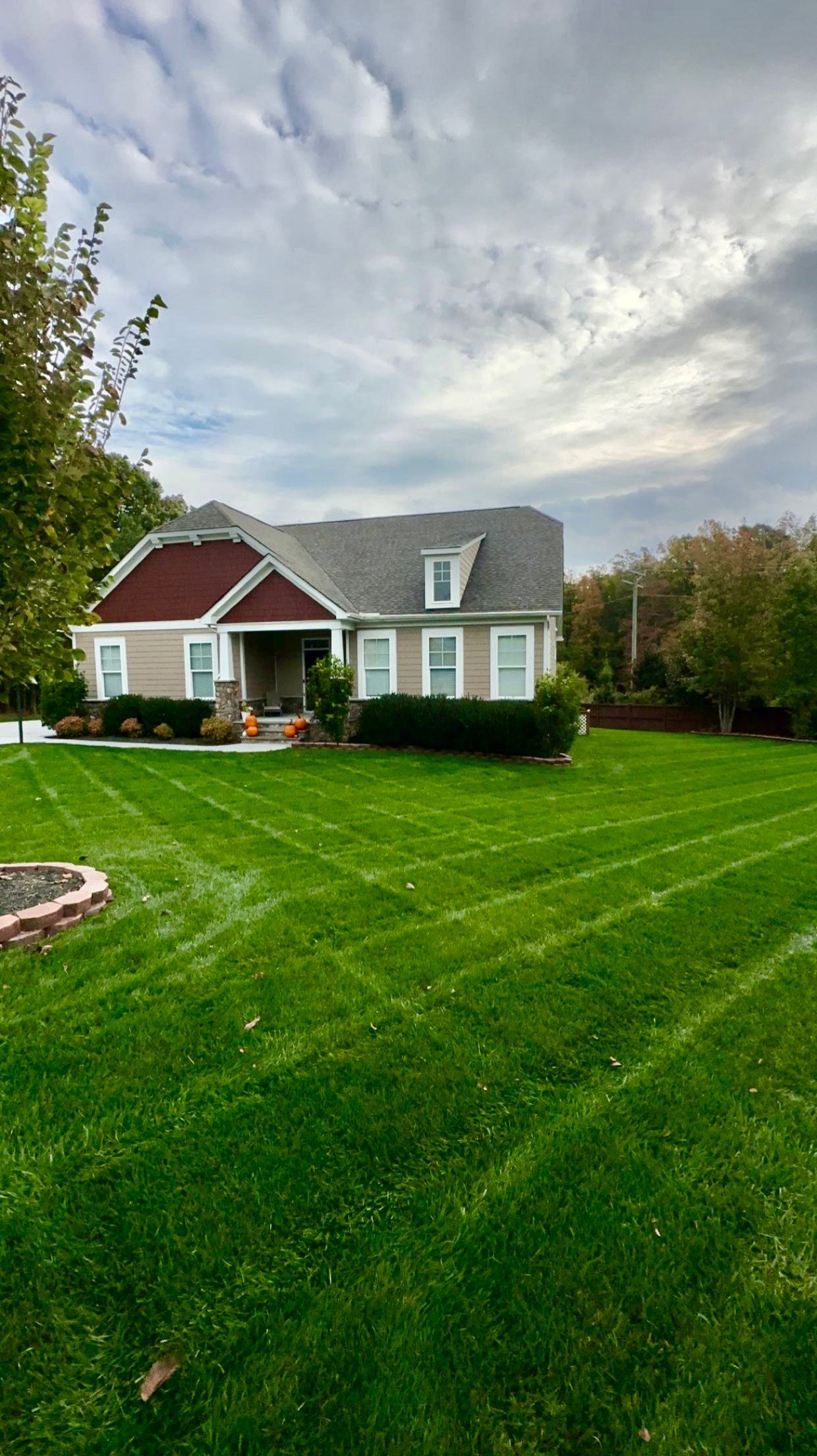 A house with a lush green lawn in front of it.