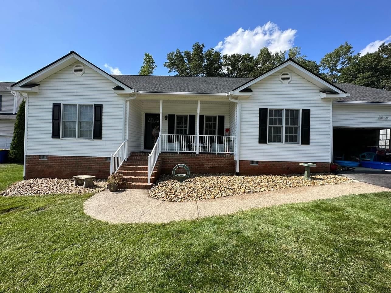 A white house with black shutters and a porch
