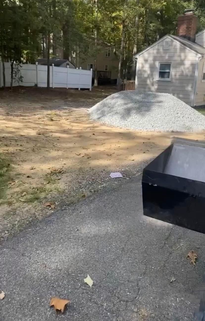 A black box is sitting on the side of a road in front of a house.