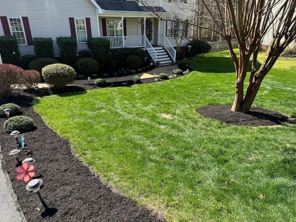 A lush green lawn with a white house in the background.