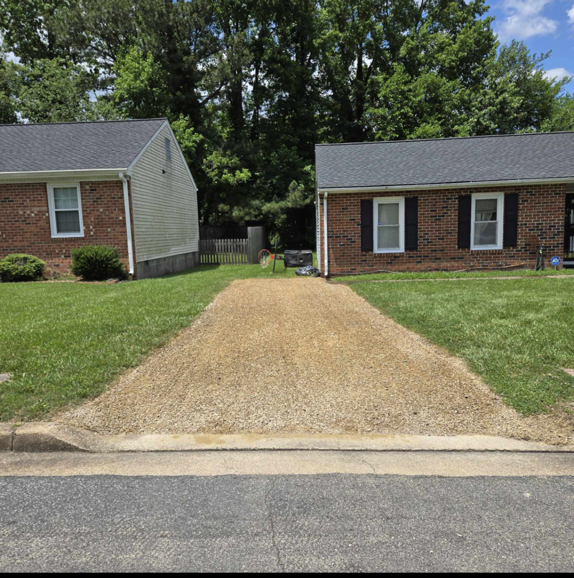 A gravel driveway leading to a brick house