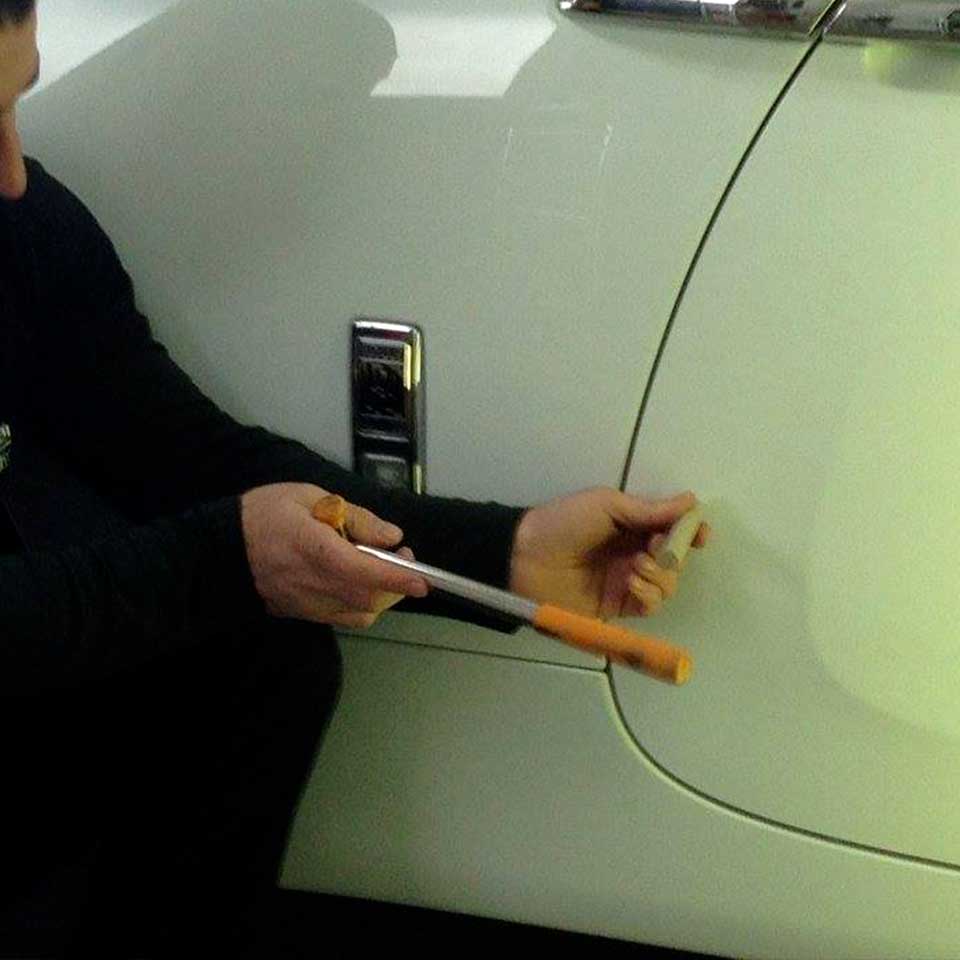 man working on car door