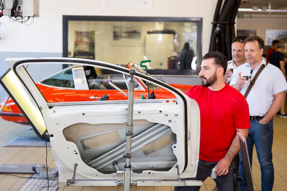 man working on side door dressed in red