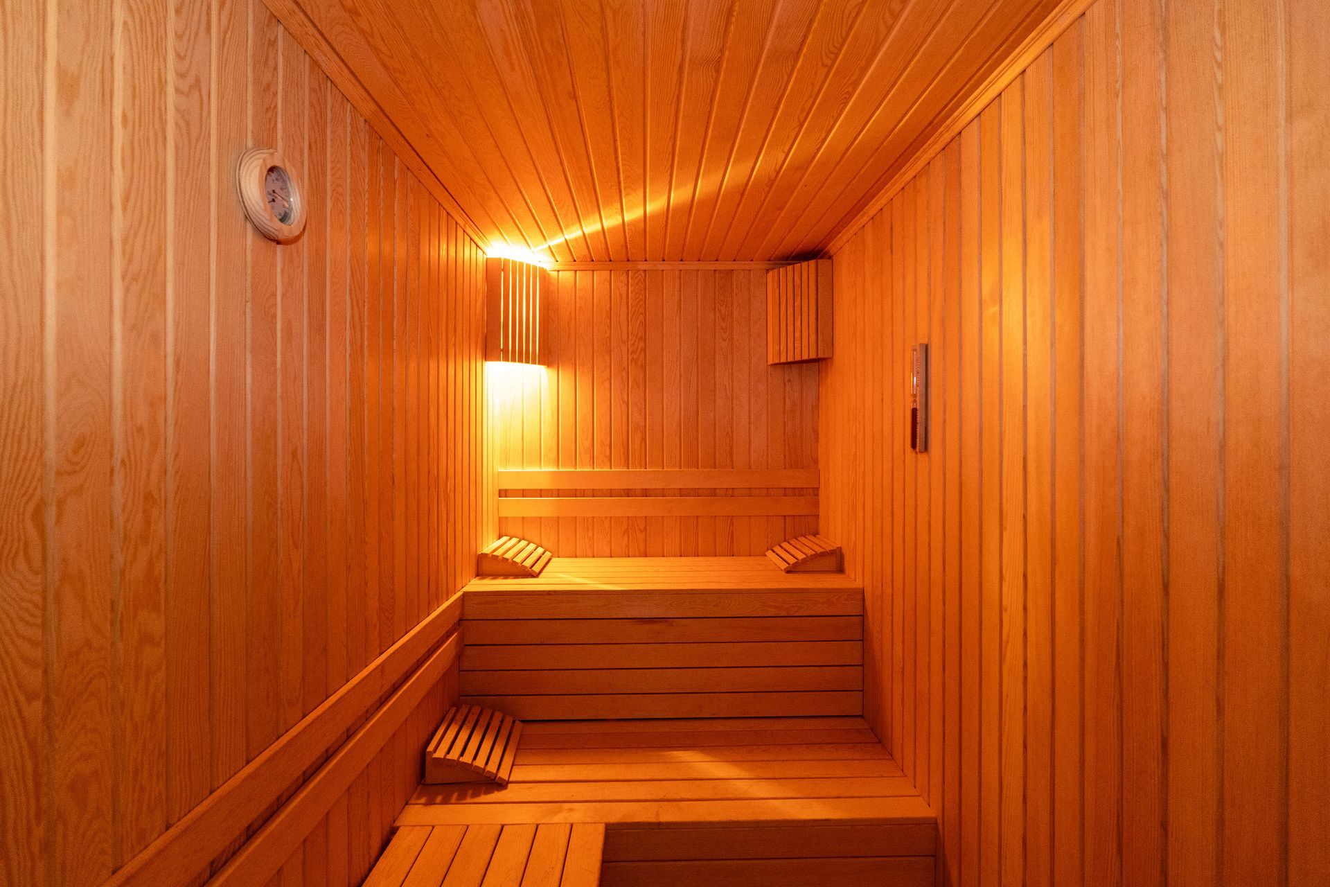 Istanbul By Rich Hotel | Spa | Wooden sauna with benches and a heater, warm light.